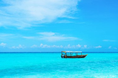 Kumlu sahilde güneşli güzel bir günün panoramik manzarası ve Zanzibar 'da balıkçı teknesi..