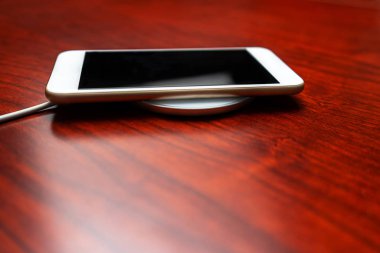 Mobile smart phone charging wirelessly by sharing battery via device.