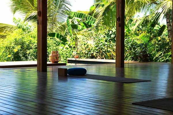 Open tropical yoga studio place with view outside to the beautiful garden with palm trees and ocean. — Stock Photo, Image