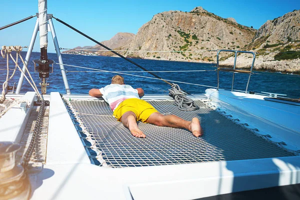 Happy young man feels happy on the luxury sail boat yacht catamaran in turquoise sea in summer holidays on island. — Stock Photo, Image