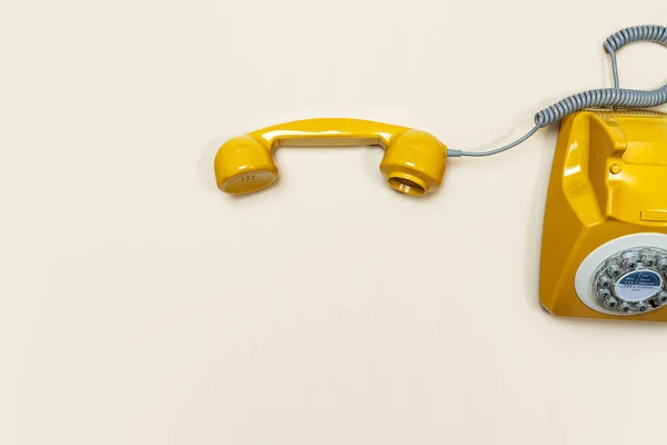 Auricular anticuado sobre fondo de color beige. Moderno estilo retro de teléfono giratorio . — Foto de Stock