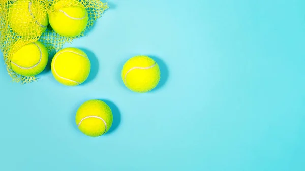 Tennisbollar nära på rosa papper och blå tennisbana. — Stockfoto