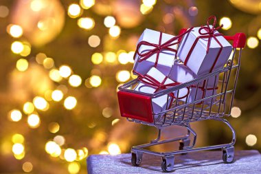 Noel süsleri, paketlenmiş hediyelerle dolu küçük bir alışveriş arabası. 