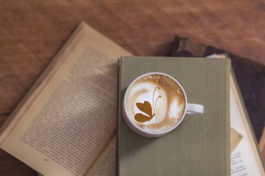 Kelebek kapuçino latte sanatıyla sıcak kahvenin en üst görüntüsü 