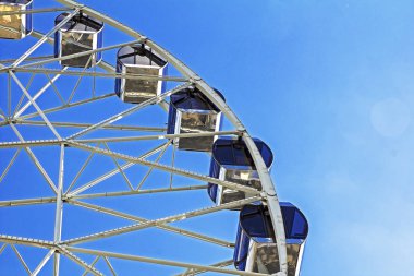 Parktaki dönme dolap mavi gökyüzü arka planında 