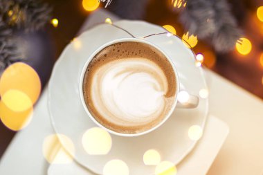 Seramik bardakta sıcak kahve kapuçino latte sanatının en üst görüntüsü.