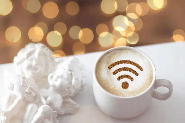 A cup of cappuccino coffee with painted cinnamon on milk foam with a wi-fi symbol