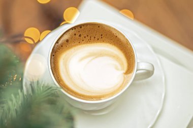 Seramik bardakta sıcak kahve kapuçino latte sanatının en üst görüntüsü.