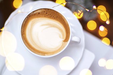 Seramik bardakta sıcak kahve kapuçino latte sanatının en üst görüntüsü.