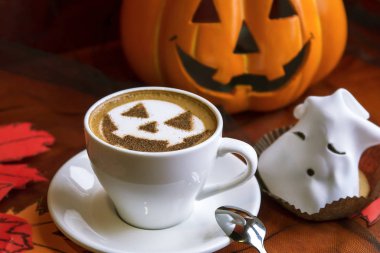 Bir fincan cadılar bayramı sembollü kapuçino. Süt köpüklü latte sanatı.