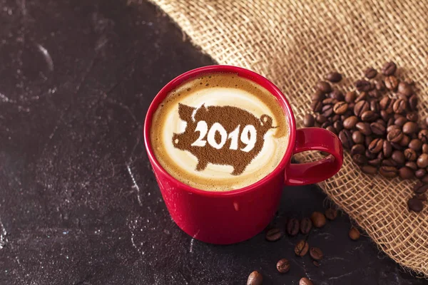 coffee cappuccino in a cup with a pattern of the symbol of 2019 pig on milk foam. The pig is a symbol of the year 2019 in the Chinese calendar.