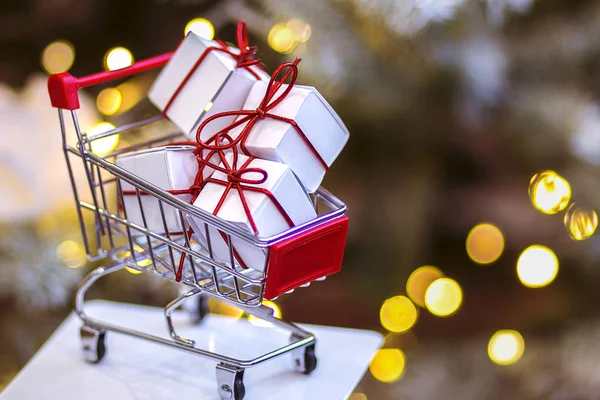 Stock image christmas decorations , small shopping cart with wrapped presents 