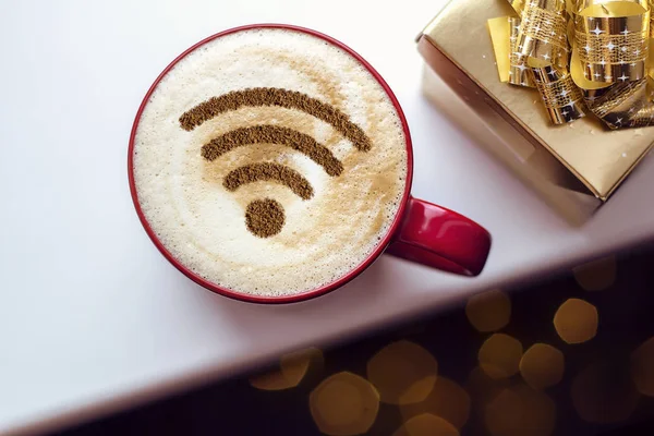 A cup of cappuccino coffee with painted cinnamon on milk foam with a wi-fi symbol