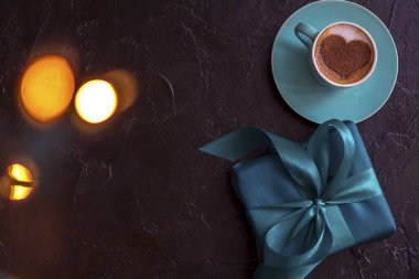 hot coffee cappuccino with latte art of romantic heart and wrapped gift box