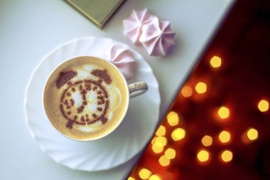 Sıcak kapuçino kahve, beyaz fincanda klasik çalar saat latte sanatı.