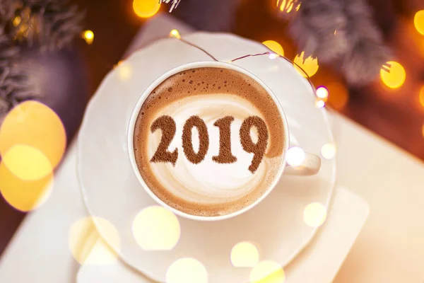 a cup of cappuccino coffee with a symbol of the NEW YEAR 2019 on milk foam
