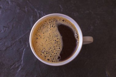 Siyah arka planda bir fincan sıcak çay.