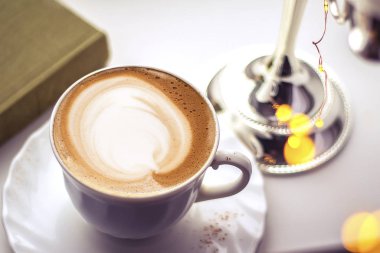 Seramik bardakta sıcak kahve kapuçino latte sanatının en üst görüntüsü.