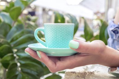 Elinde bir fincan naneli kahve.
