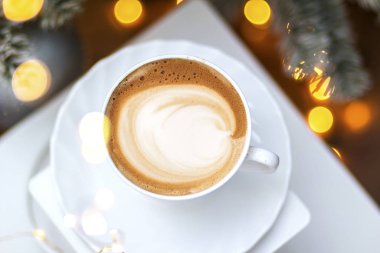 Seramik bardakta sıcak kahve kapuçino latte sanatının en üst görüntüsü.