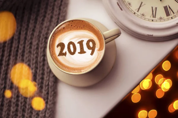 a cup of cappuccino coffee with a symbol of the NEW YEAR 2019 on milk foam