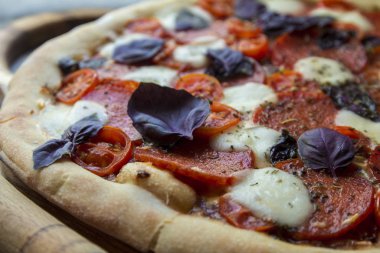 homemade pizza with bazil, tomatoes and cheese