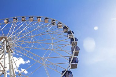 Parktaki dönme dolap mavi gökyüzü arka planında 