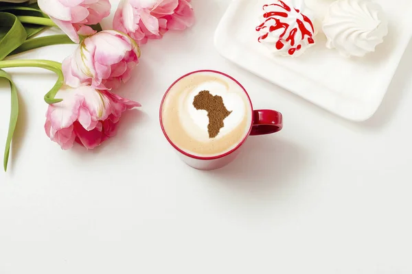 A cup of cappuccino coffee with a pattern on milk foam from cinnamon in the form of Africa