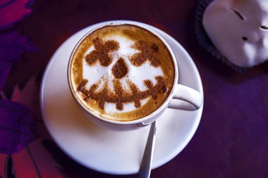 cup of cappuccino coffee with halloween holiday pattern