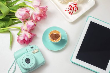  Sıcak kahve cappuccino ile latte romantik kalp sanatı. Pembe laleler ve tablet bilgisayar 