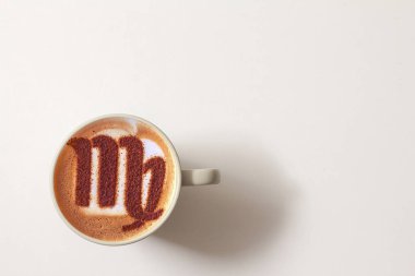 Bir fincan cappuccino kahve ve burç sembolü.