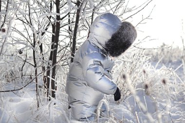 Kar parkındaki kışlık elbiseli çocuk.