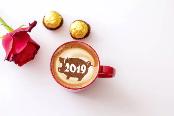 coffee cappuccino in a cup with a pattern of the symbol of 2019 pig on milk foam. The pig is a symbol of the year 2019 in the Chinese calendar.