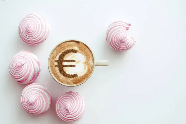 cup of coffee cappuccino with a picture of a Euro sign from cinnamon on milk foam