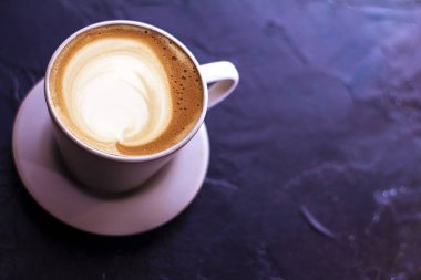 Seramik bardakta sıcak kahve kapuçino latte sanatının en üst görüntüsü.