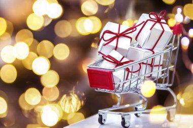 Noel süsleri, paketlenmiş hediyelerle dolu küçük bir alışveriş arabası. 