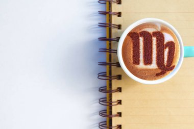 Bir fincan cappuccino kahve ve burç sembolü.