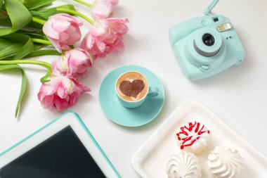  Sıcak kahve cappuccino ile latte romantik kalp sanatı. Pembe laleler ve tablet bilgisayar 