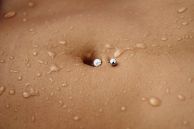 Su damlacıkları dişinin karnına piercing ile düşer.