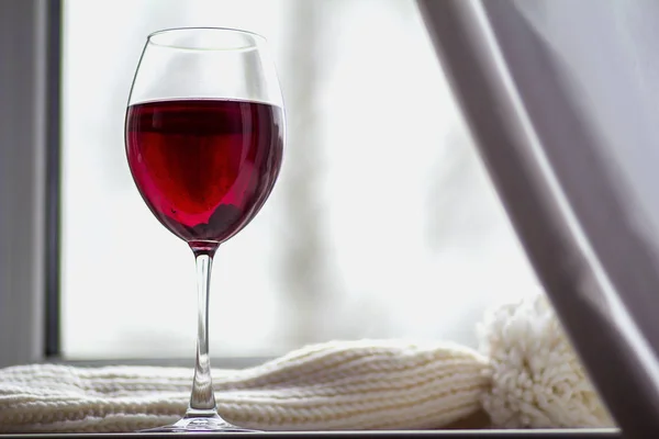 red wine in a large glass fouger on the window sill on a cold winter day