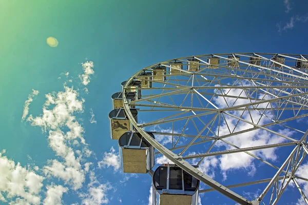 Parktaki dönme dolap mavi gökyüzü arka planında 