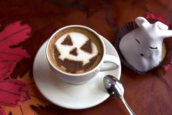 cup of cappuccino coffee with halloween symbol latte art on milk foam