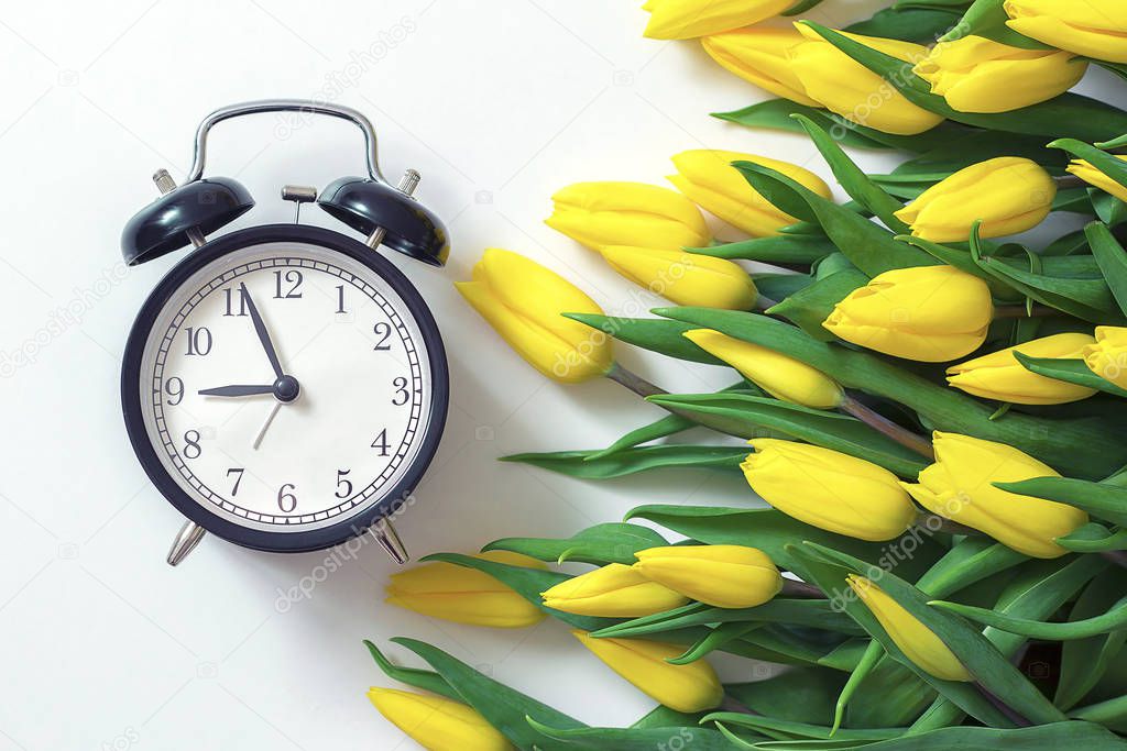 yellow tulips bouquet and vintage alarm clock
