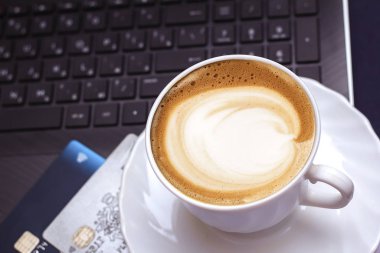 Seramik bardakta sıcak kahve kapuçino latte sanatının en üst görüntüsü.