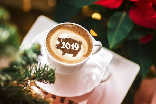 coffee cappuccino in a cup with a pattern of the symbol of 2019 pig on milk foam. The pig is a symbol of the year 2019 in the Chinese calendar.