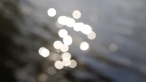 lumières bokeh brillant contre l'ondulation de l'eau floue  