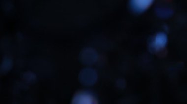 Koyu arkaplanda parlayan mavi bokeh ışıkları