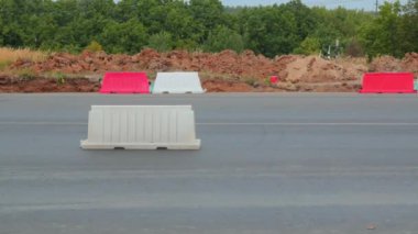Kırmızı ve beyaz ağır plastik bariyerler, yolda ekipman barikatları