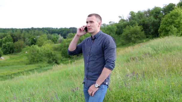 Joven hablando por teléfono al aire libre — Vídeo de stock