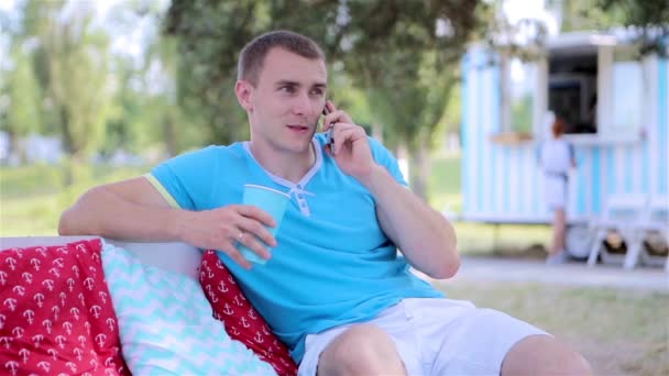 Młody człowiek rozmawia przez telefon odkryty — Wideo stockowe